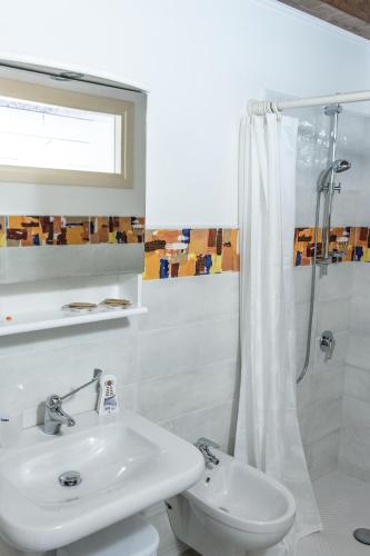 a white bathroom with a sink and a shower at La Casa di Santino in Comacchio
