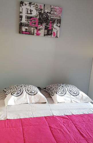 - un lit avec deux oreillers et une affiche murale dans l'établissement Studio Naturiste 