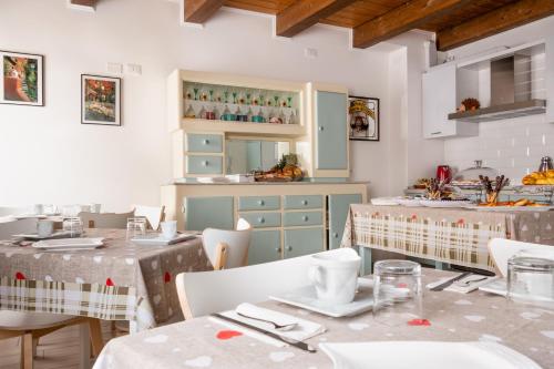 una sala da pranzo con 2 tavoli e una cucina di La Casa di Santino a Comacchio