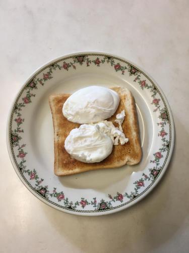Dos huevos sobre una tostada en un plato. en Avoca Villa Guest House, en Saint Helier Jersey