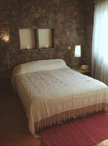 a bedroom with a bed and a stone wall at Holiday Home in Sfendouri, Aegina in Sfendoúrion