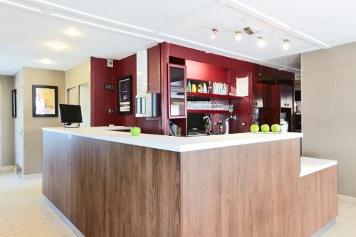 a kitchen with red cabinets and a counter top at Campanile Maubeuge in Maubeuge