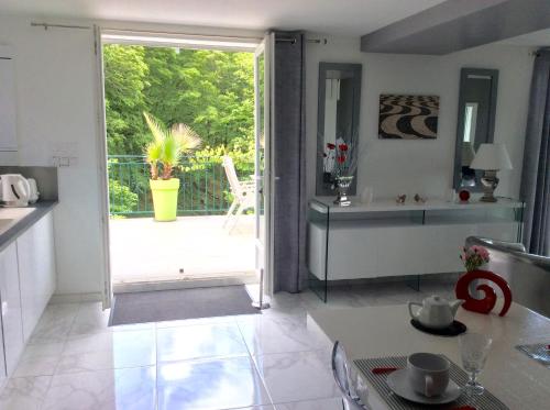 a kitchen with a door open to a patio at Suite panoramique à Tulle in Tulle