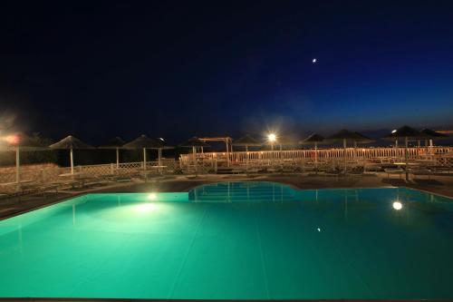 a large swimming pool at night with lights at MORF suites in Casale Marittimo