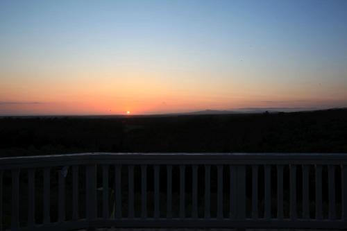 a sunset seen from a balcony with a fence at MORF suites in Casale Marittimo