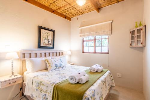 a bedroom with two towels on a bed at Elfen Cottage in Prince Albert