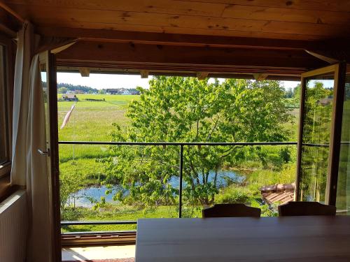 a room with a table and a view of a field at Koanzhaus, Troadkasten in Franking