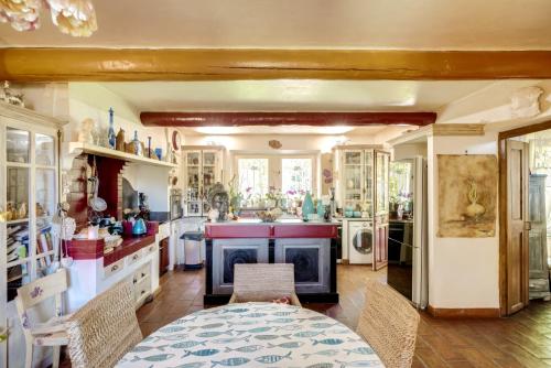 una grande cucina con un tavolo e una stufa di Le Mas des Anges a Cheval-Blanc