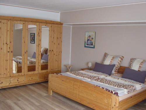 a bedroom with a wooden bed and a wooden cabinet at Haus am Wald in Hillscheid