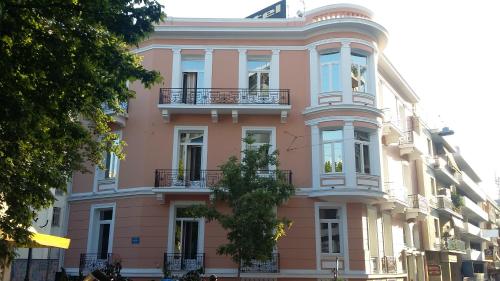 a pink building with balconies on a city street at Exis Hotel in Athens