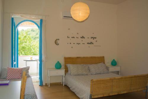 1 dormitorio con 1 cama con escritura en la pared en Benvenuti Nel Sud, en Sessa Cilento
