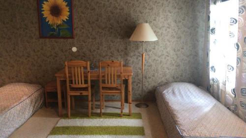 ein Esszimmer mit einem Tisch, Stühlen und einer Lampe in der Unterkunft Majatalo Eura in Eura