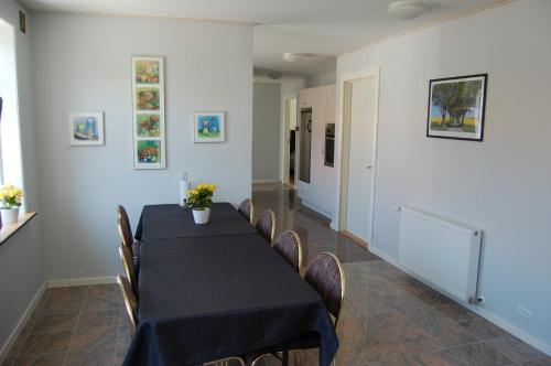 a dining room with a black table and chairs at Nordgården Pension in Onsbjerg