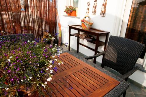 a table and a chair and flowers on a porch at Attico rooms in Giardini Naxos