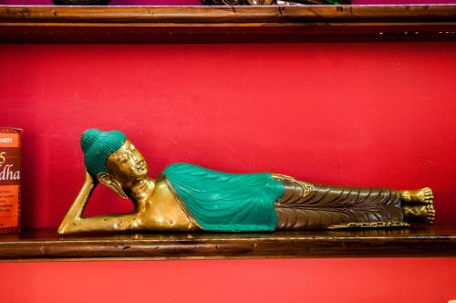 a gold statue of a woman laying on a shelf at Attico rooms in Giardini Naxos