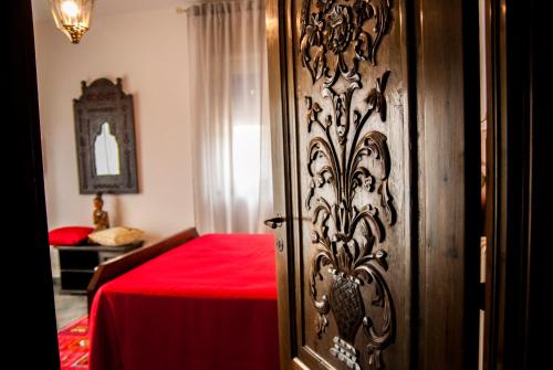 a bedroom with a red bed and a wooden door at Attico rooms in Giardini Naxos