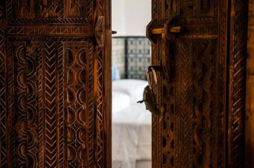 an open wooden door with a bed in the background at Attico rooms in Giardini Naxos