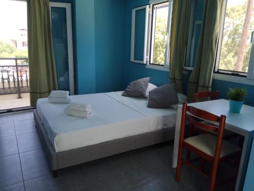 um quarto com uma cama e uma mesa com uma cadeira em Monte Blu Holiday Apartment em Alykes