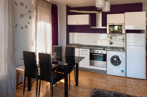 eine Küche mit einem Esstisch und eine Küche mit einer Waschmaschine in der Unterkunft Apartamento A pie de Playa in Miño