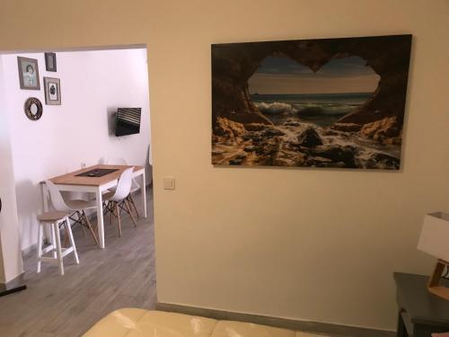 a painting hanging on a wall in a room with a table at Maxorata City Center Fuerteventura in Morro del Jable