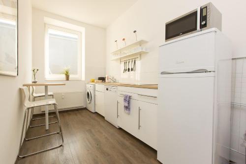 
a kitchen with white cabinets and white appliances at T3 Hotel Cityloft in Mönchengladbach
