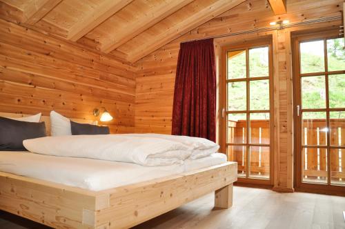 BschlabsにあるAuszeit Chaletsの木製の部屋にベッド1台が備わるベッドルーム1室があります。
