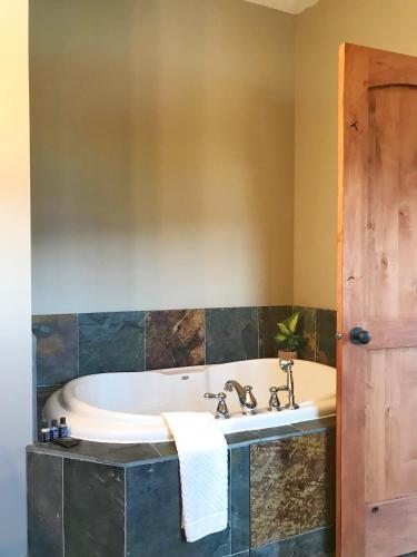 a bath tub in a bathroom with a sink at Wesbert Winery & Guest Suites in Penticton
