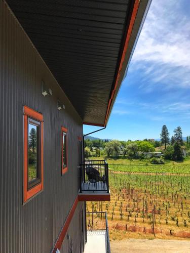 a building with a balcony with a view of a vineyard at Wesbert Winery & Guest Suites in Penticton