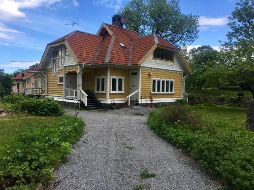 a yellow house with a red roof at Pensionat Kanalvillan in Väddö