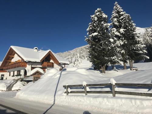 a house covered in snow next to a fence at Chalet Romy Ap2 in Pramauron