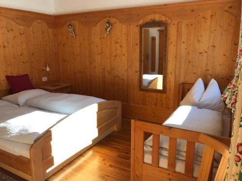 two beds in a room with wooden walls at Chalet Romy Ap2 in Pramauron