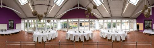 a room with white tables and chairs in a building at Forsthof in Steinheim an der Murr