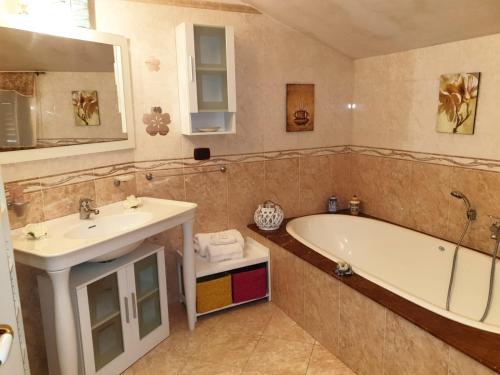 een badkamer met een bad en een wastafel bij LillyBoat in Plemmirio