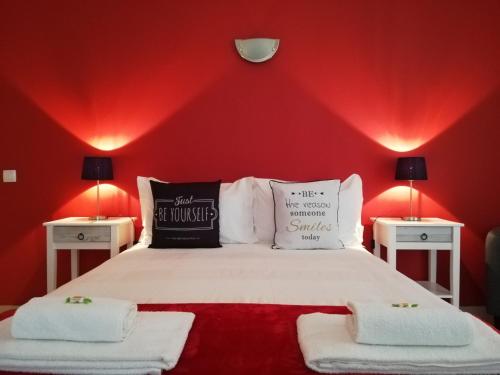 una camera da letto con pareti rosse e un letto con due tavoli di Blue Moon Guesthouse a Lagos