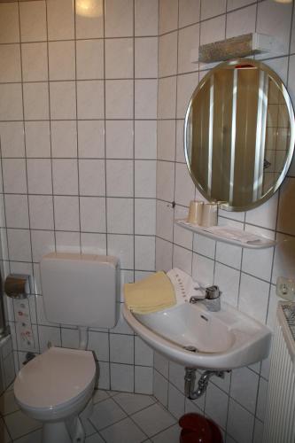 ein Badezimmer mit einem Waschbecken, einem WC und einem Spiegel in der Unterkunft Haus Klosterblick in Kröv