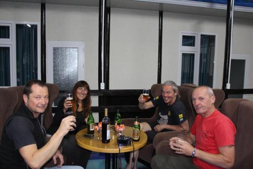 a group of people sitting around a table with drinks at Park Hostel Osh in Osh
