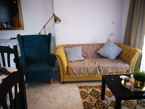 ein Wohnzimmer mit einem Sofa und einem blauen Stuhl in der Unterkunft Hola Gandia in Gandía