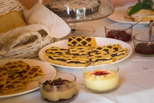 un tavolo sormontato da piatti di waffle e altri dessert di Casa Rana a Recanati