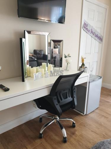 a white desk with a chair and a mirror at The Winter Garden Suites in Blackpool