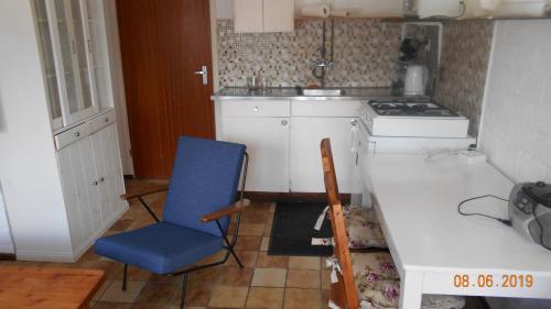 a kitchen with a blue chair and a stove at Familie Vakantiewoning Burgh-Haamstede in Burgh Haamstede