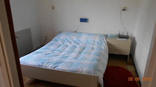 a small bedroom with a bed and a night stand at Familie Vakantiewoning Burgh-Haamstede in Burgh Haamstede