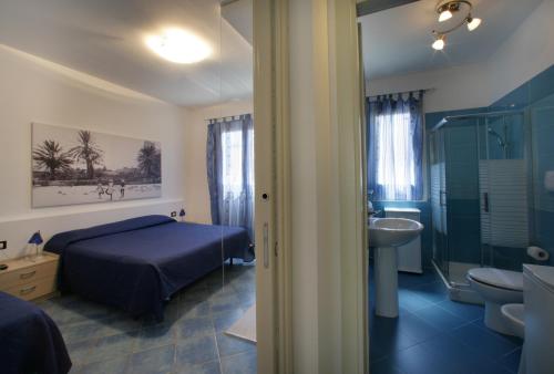 a bedroom with a bed and a bathroom with a sink at Venere ed Enea - Appartamenti Vista Mare in San Vito lo Capo