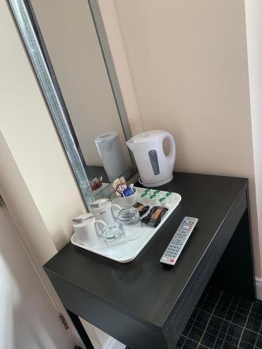 a table with a tray with cups and a remote control at Royal Hotel in Dingwall