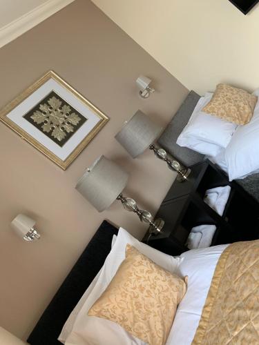 a bedroom with two beds and two lamps on the wall at Royal Hotel in Dingwall