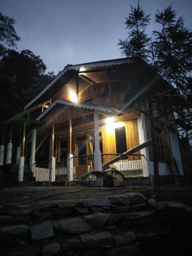 a house with lights on the front of it at night at Yuma Homestay in Mangpu