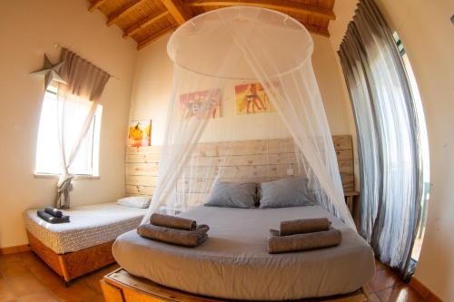 a bedroom with a bed with a mosquito net at Mayla Surf House in Aljezur