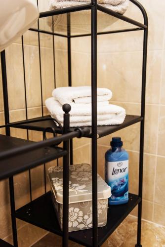 a black towel rack with towels and a bottle of cleaner at Apartment Sea&Sky in Tivat