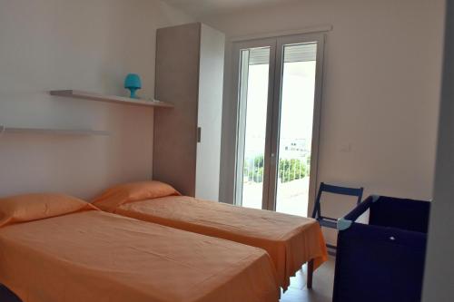 1 dormitorio con 2 camas y ventana con vistas en Casa mare Torre Pali Salento, en Torre Pali