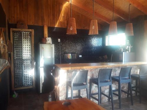 eine Küche mit einer Bar mit Stühlen und einem Kühlschrank in der Unterkunft Alto Ciprés in Salamanca