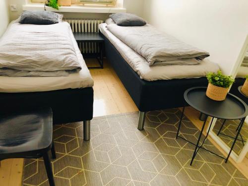 two beds in a room with a table and chairs at Scandinavian Sweet home 18 Heart of City in Helsinki